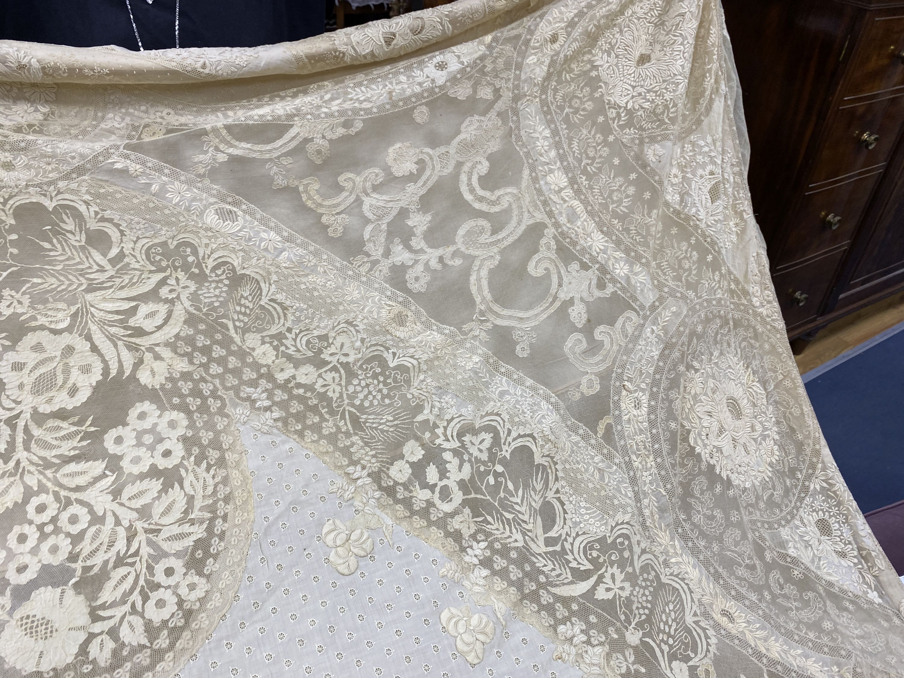 An Edwardian hand made lace bedspread. Hand sewn using finely spun lawn, decorated with Carrickmacross and white work embroidery, edged in bobbin lace. Possibly made as part of a trousseau.